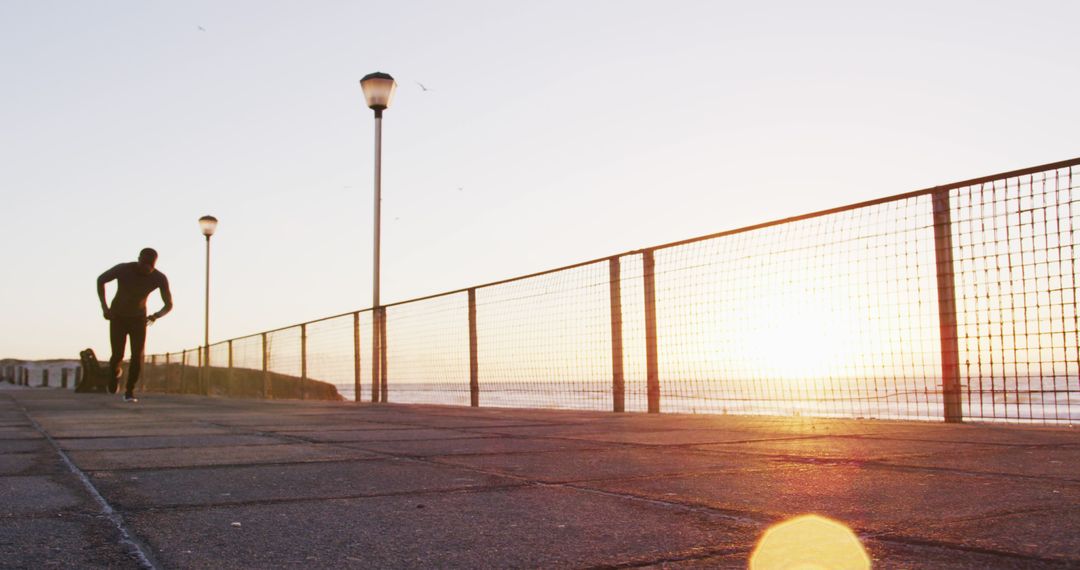 Runner Taking a Break at Sunrise by Seaside Promenade - Free Images, Stock Photos and Pictures on Pikwizard.com