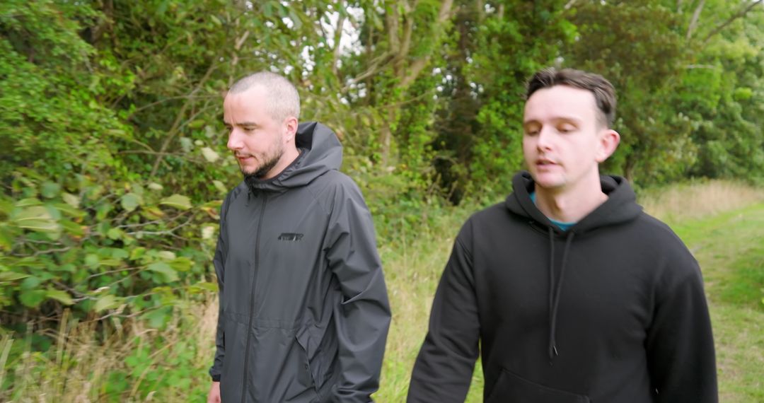 Two Men Walking through Lush Green Park Enjoying Outdoor Exercise