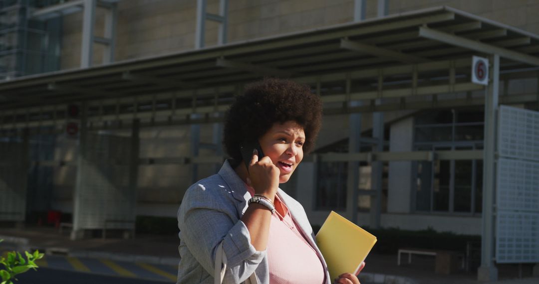 Professional Plus Size Woman on Phone in Urban Setting with Notebooks