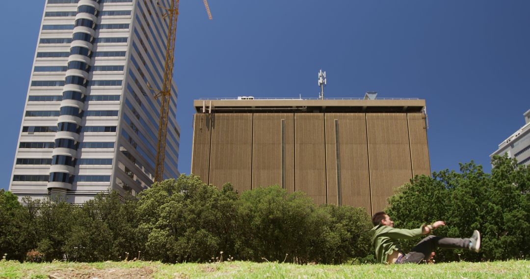 Person Relaxing in Urban Park with Tall Buildings in Background - Free Images, Stock Photos and Pictures on Pikwizard.com