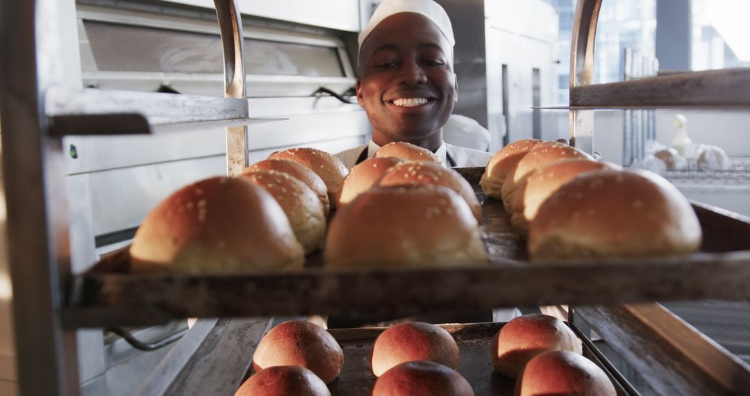 Smiling Baker Presenting Freshly Baked Buns in Bakery - Free Images, Stock Photos and Pictures on Pikwizard.com