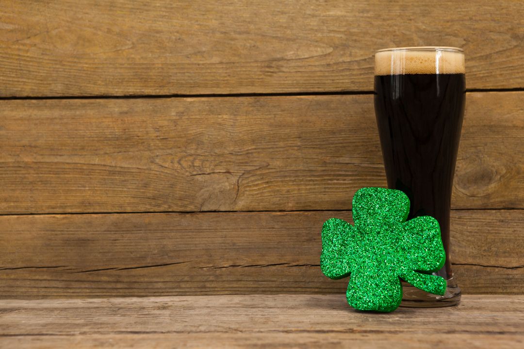St. Patrick's Day Black Beer and Shamrock on Wooden Background - Free Images, Stock Photos and Pictures on Pikwizard.com