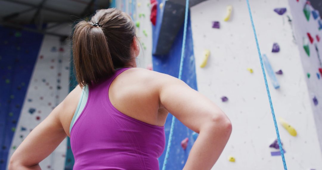 Determined Woman Facing Indoor Climbing Wall with Speech Bubbles