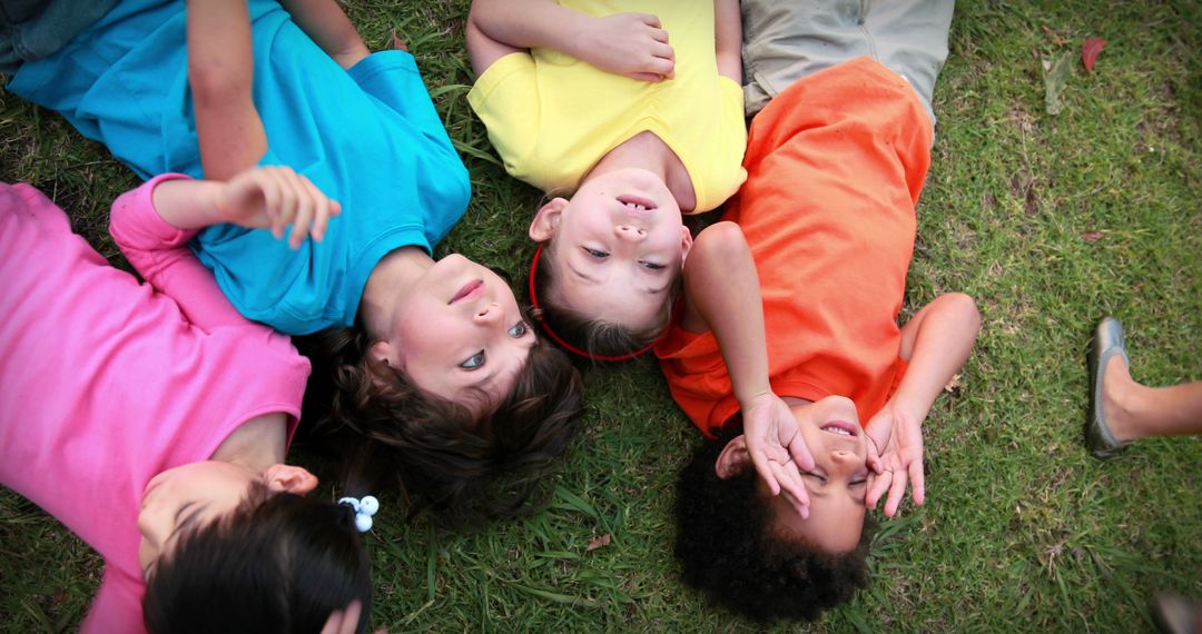 Happy Children Lying in Grass and Smiling Outdoors - Free Images, Stock Photos and Pictures on Pikwizard.com