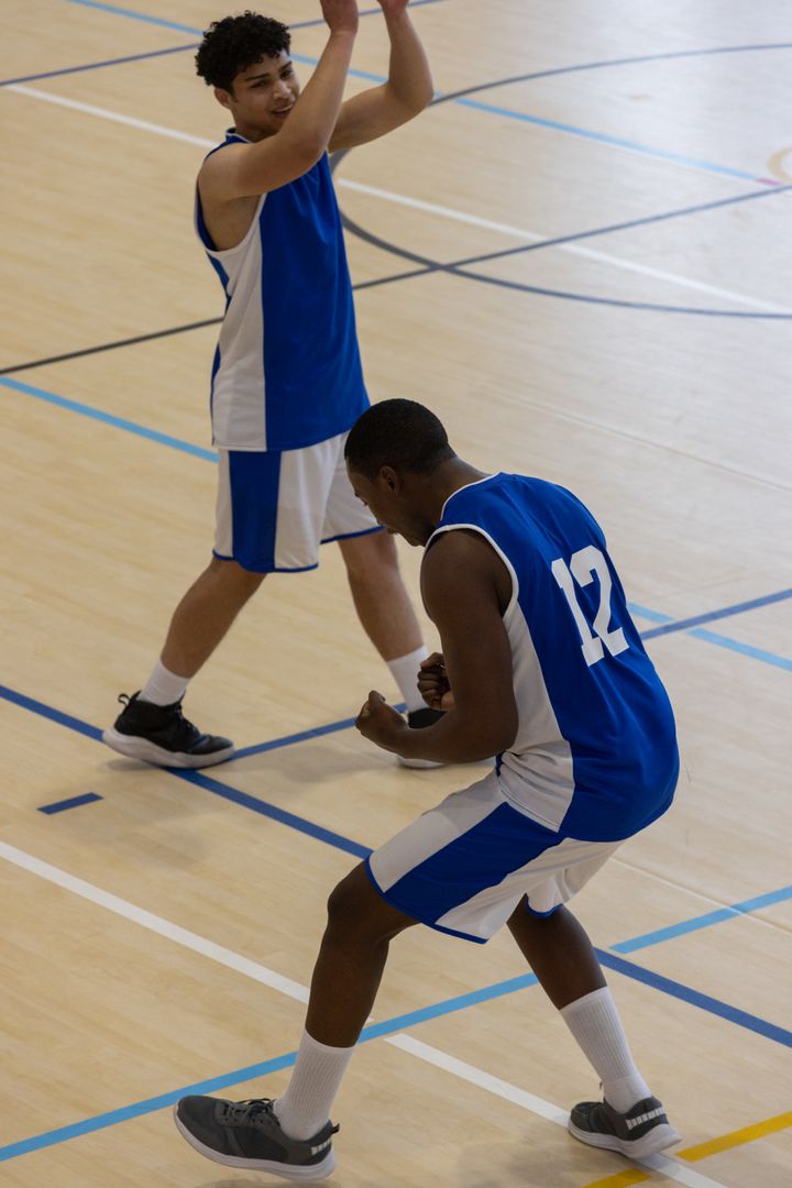 Dynamic Teammate Celebration on Basketball Court in Energetic Moment