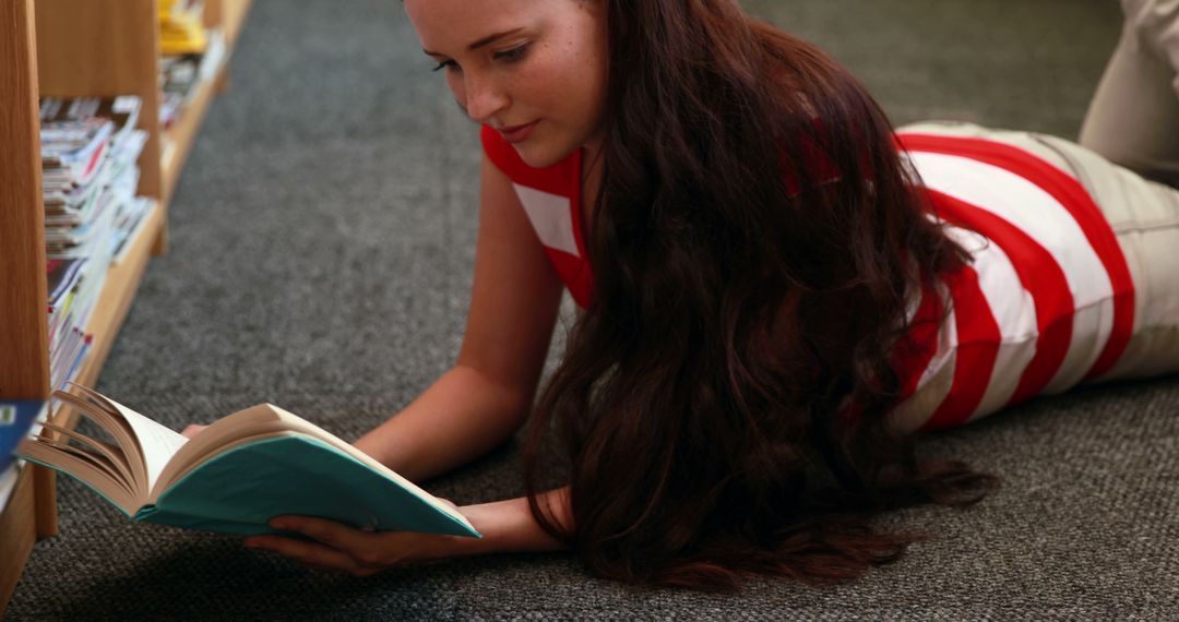 Woman Lying on Floor in Library Reading Book - Free Images, Stock Photos and Pictures on Pikwizard.com