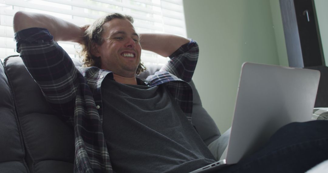 Relaxed Man Smiling While Browsing Laptop on Couch at Home - Free Images, Stock Photos and Pictures on Pikwizard.com