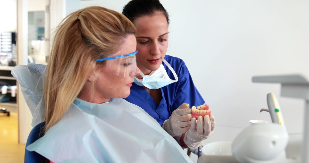 Dentist Explaining Dental Procedure to Female Patient in Office - Free Images, Stock Photos and Pictures on Pikwizard.com