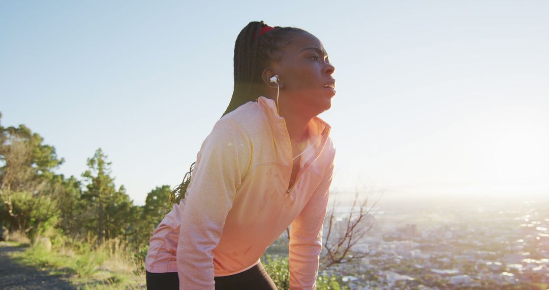 African american woman exercising outdoors wearing earphones preparing to run in countryside - Free Images, Stock Photos and Pictures on Pikwizard.com