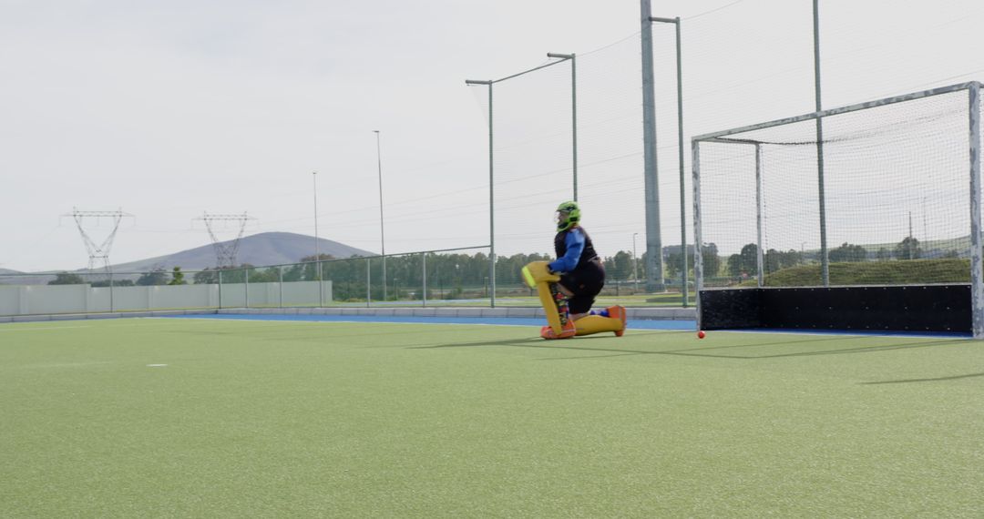 Female Field Hockey Goalkeeper in Action on Turf with Copy Space