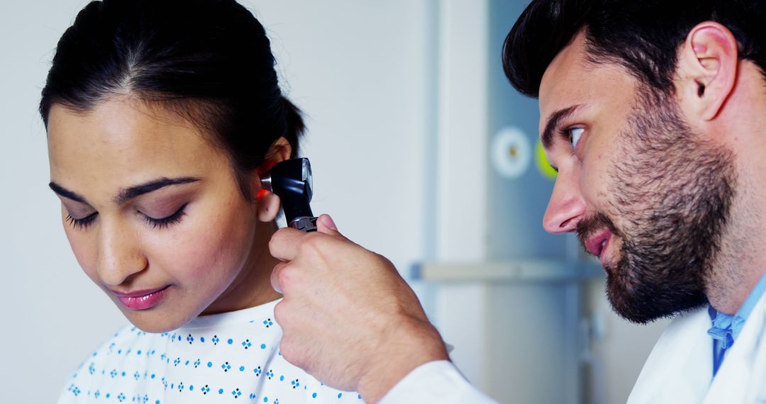 Doctor Using Otoscope to Examine Female Patient's Ear in Medical Check-Up - Free Images, Stock Photos and Pictures on Pikwizard.com