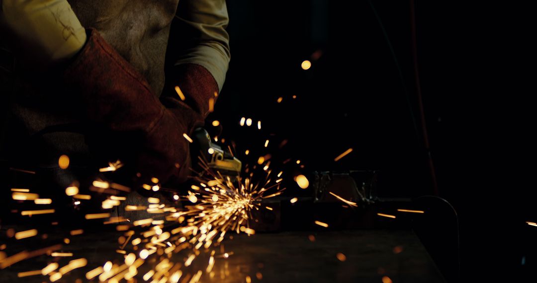 Man Working With Angle Grinder Producing Sparks in Dark Workshop - Free Images, Stock Photos and Pictures on Pikwizard.com