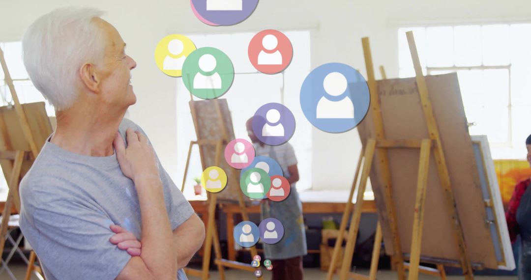 Senior Man Observing Art Class with Floating Icons in Studio