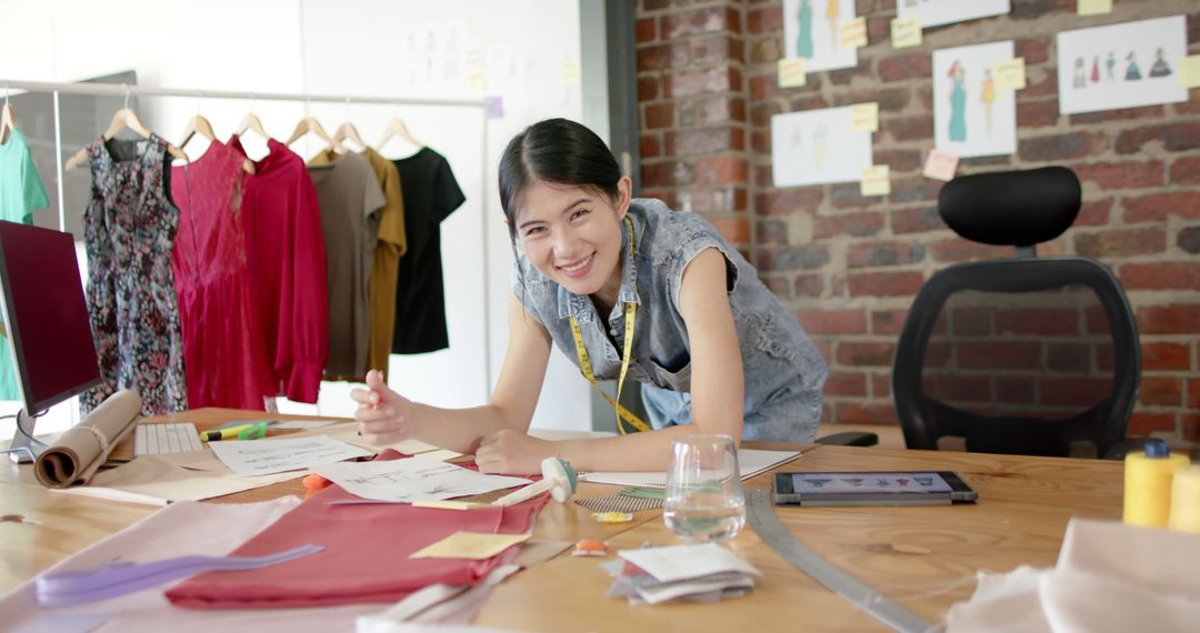 Smiling Young Fashion Designer Working at Creative Studio Desk - Free Images, Stock Photos and Pictures on Pikwizard.com