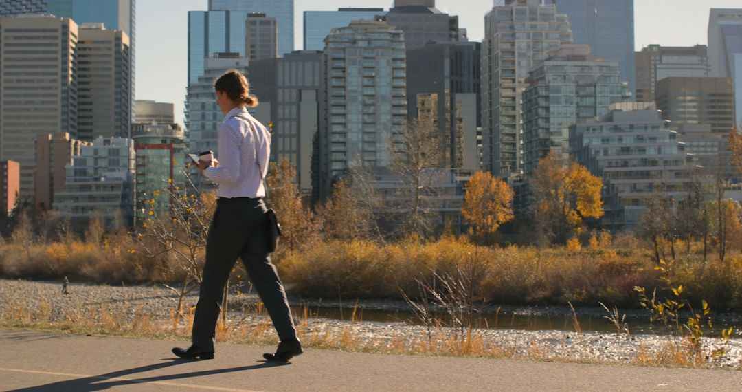 Businessman Walking Through City Park in Autumn - Free Images, Stock Photos and Pictures on Pikwizard.com