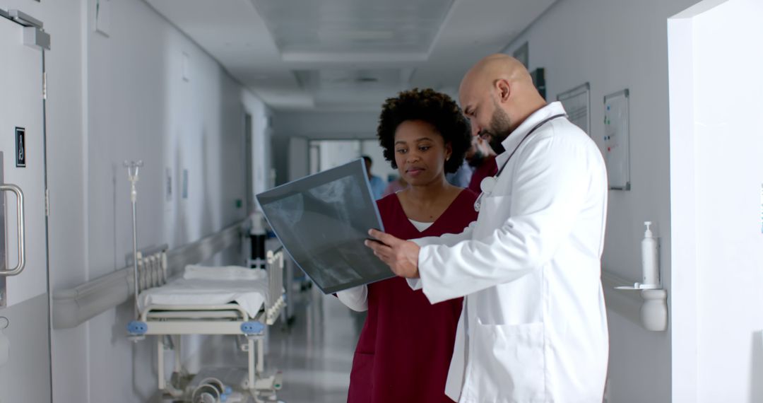 Doctors Analyzing X-Ray Results in Hospital Corridor - Free Images, Stock Photos and Pictures on Pikwizard.com