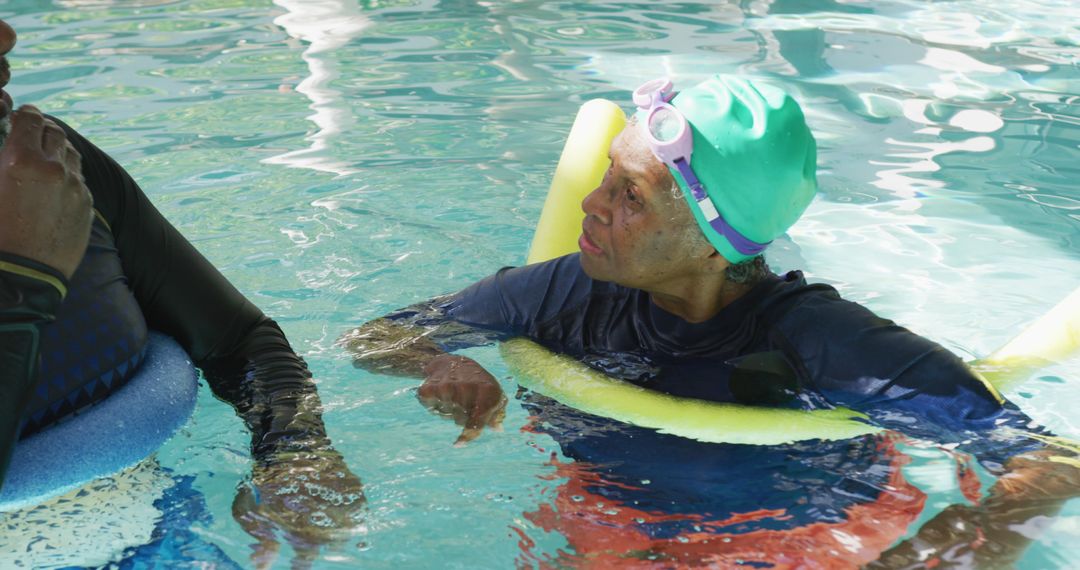 Senior Couple Enjoying Water Exercise in Pool with Pool Noodles - Free Images, Stock Photos and Pictures on Pikwizard.com