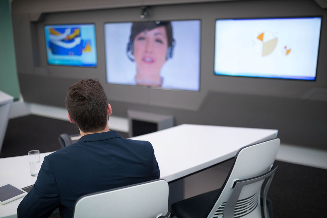 Business Professional Participating in Virtual Meeting with Monitor Displays