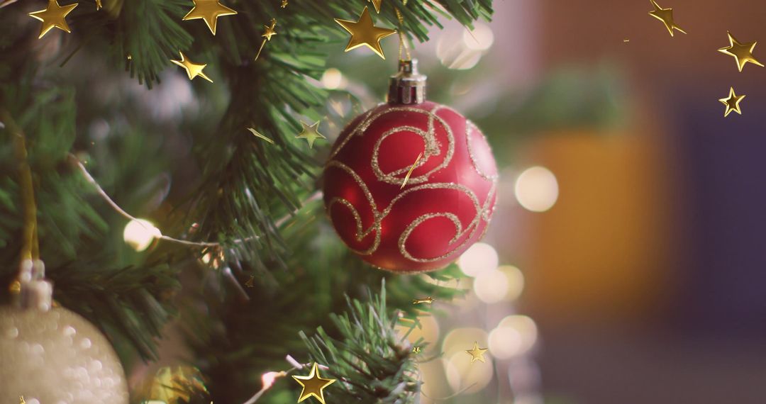 Festive Red Ornament Hanging on a Christmas Tree with Falling Stars