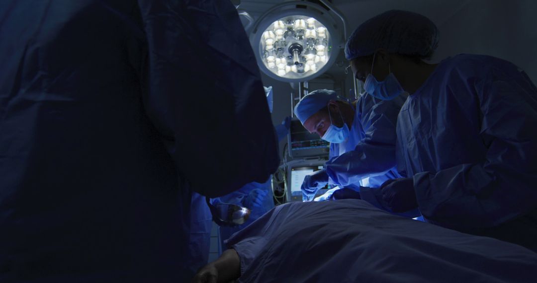 Surgeons Performing Operation in Shadowy Operating Room - Free Images, Stock Photos and Pictures on Pikwizard.com