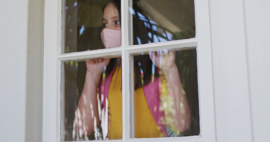 Child Looking Out Home Window Wearing Mask for Safety - Free Images, Stock Photos and Pictures on Pikwizard.com