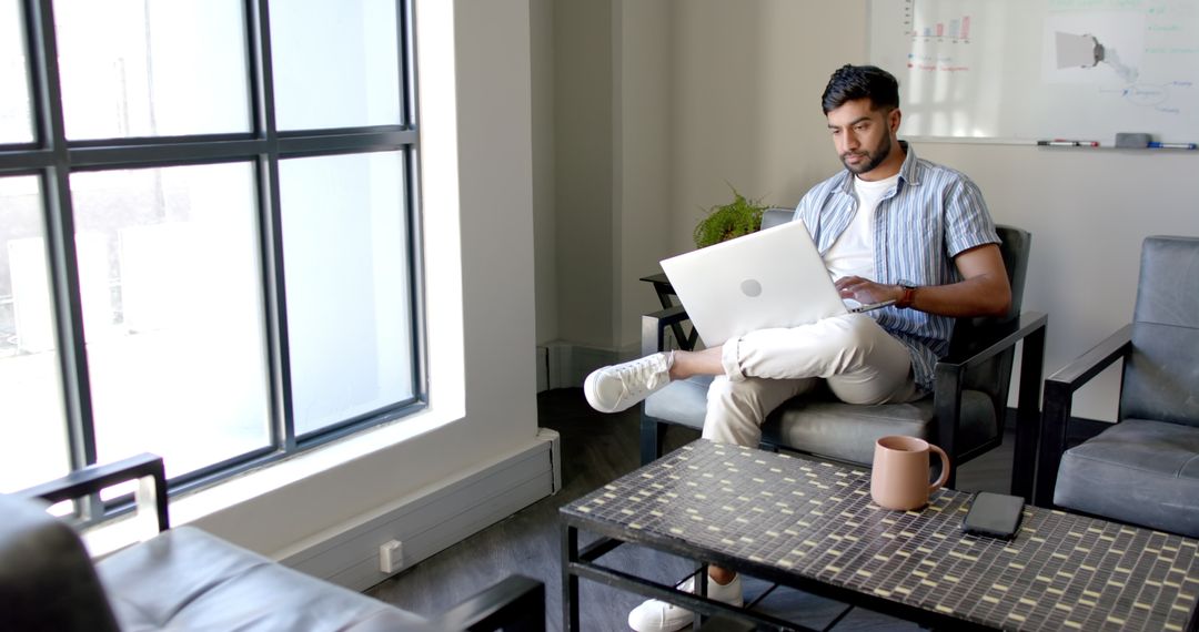 Focused Professional Using Laptop in Modern Office Workspace