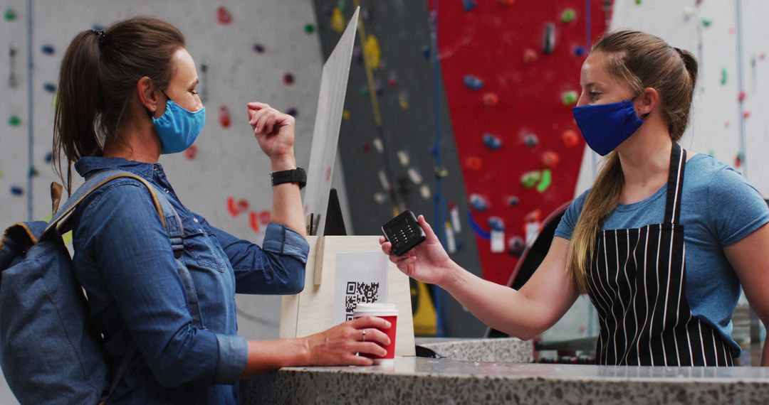 Customer paying at indoor climbing gym with face mask - Free Images, Stock Photos and Pictures on Pikwizard.com