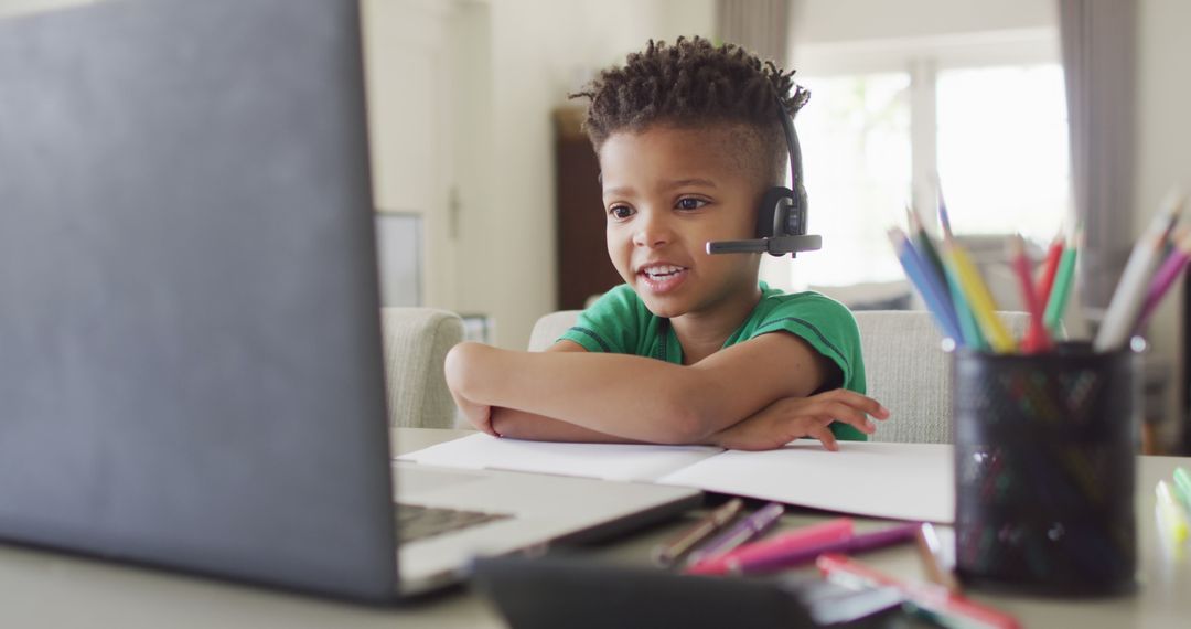 African american boy wearing headphones and having school image call on laptop - Free Images, Stock Photos and Pictures on Pikwizard.com