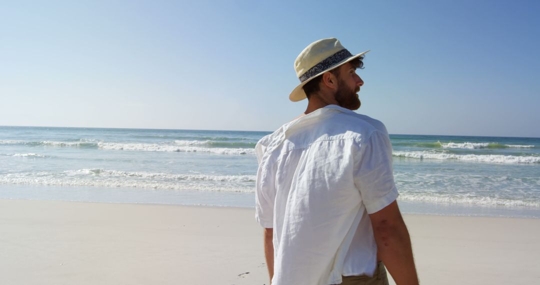 Man Enjoying Serene Beach Walk on Sunny Day - Free Images, Stock Photos and Pictures on Pikwizard.com