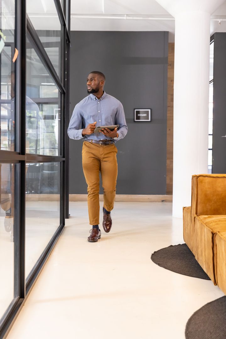 Professional Man Using Digital Tablet in Modern Office Corridor