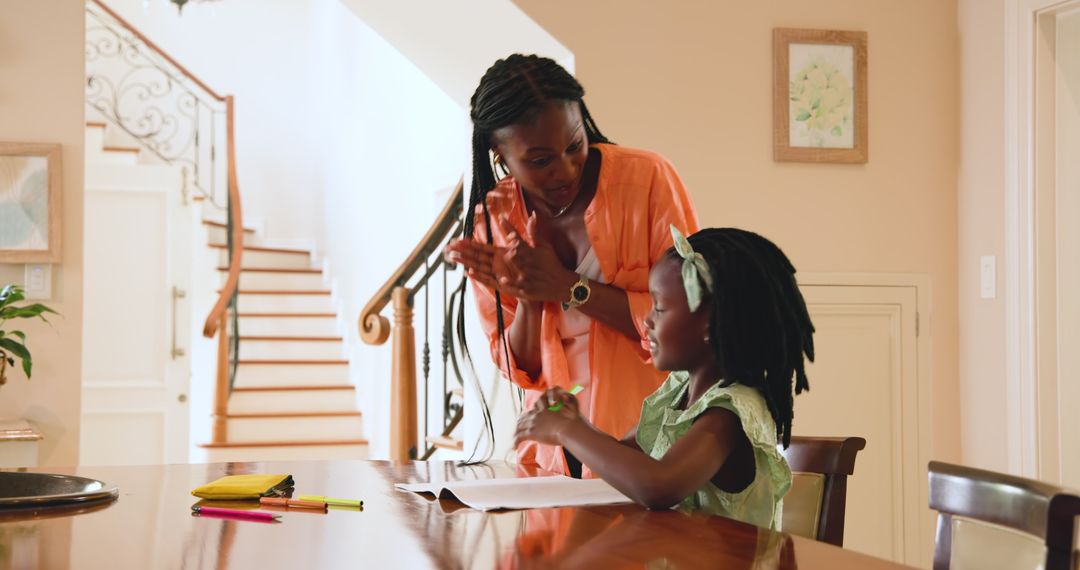 Mother Helping Daughter with Homework at Kitchen Table