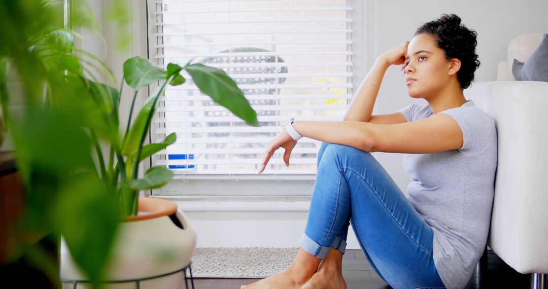 Pensive Woman Sitting by Window with Indoor Plants - Free Images, Stock Photos and Pictures on Pikwizard.com