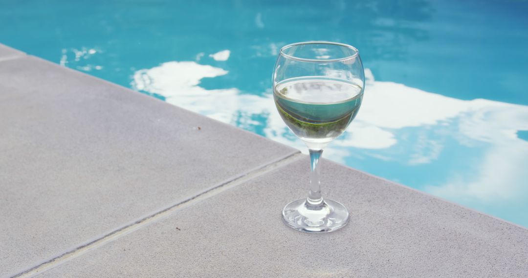 Wine Glass by Swimming Pool Reflecting Blue Sky - Free Images, Stock Photos and Pictures on Pikwizard.com