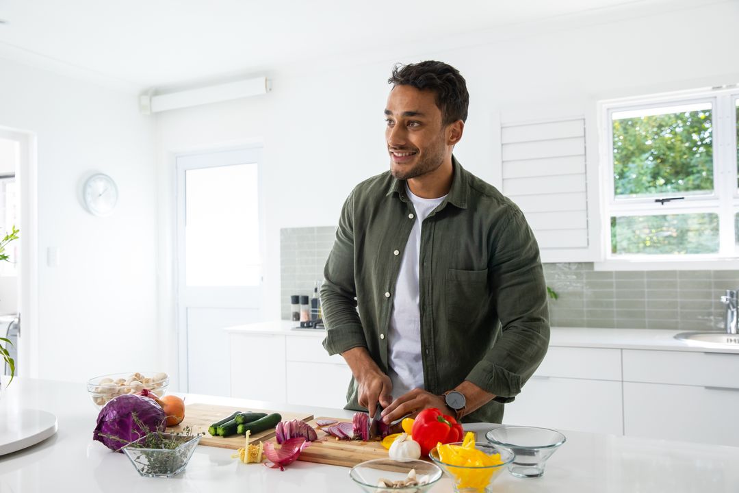 Smiling Man Chopping Vegetables in Modern Kitchen