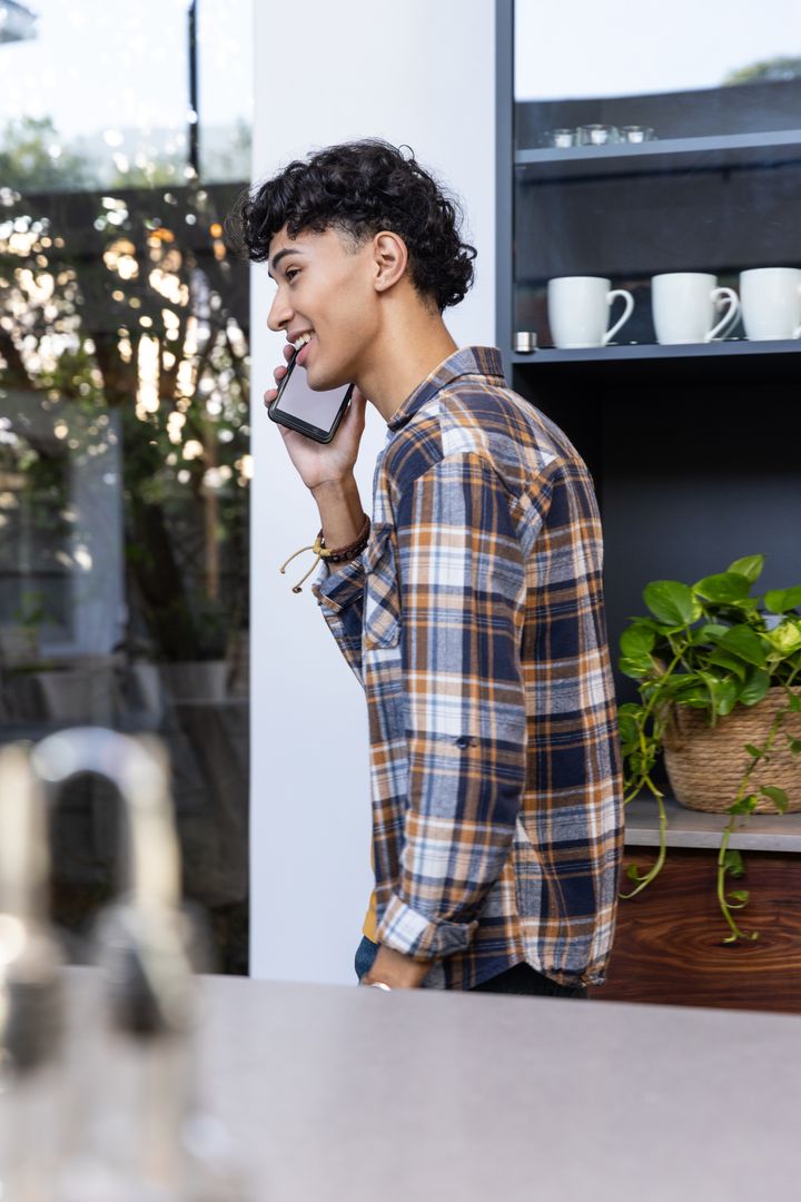 Young Man Conversing on Smartphone in Stylish Kitchen