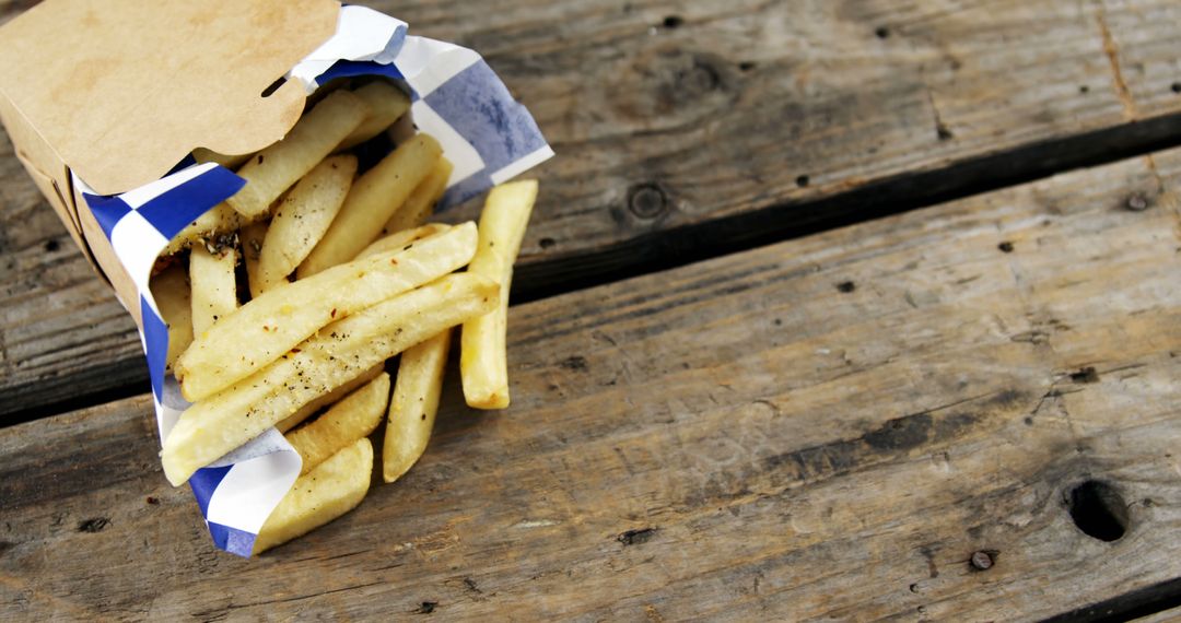 French Fries Spilling from Fast Food Paper Bag on Rustic Wooden Table - Free Images, Stock Photos and Pictures on Pikwizard.com