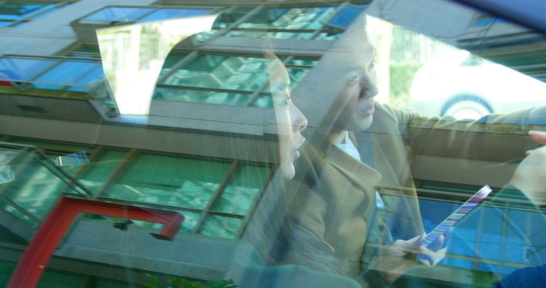 Two Women Conversing in Car with Reflections on Windows - Free Images, Stock Photos and Pictures on Pikwizard.com