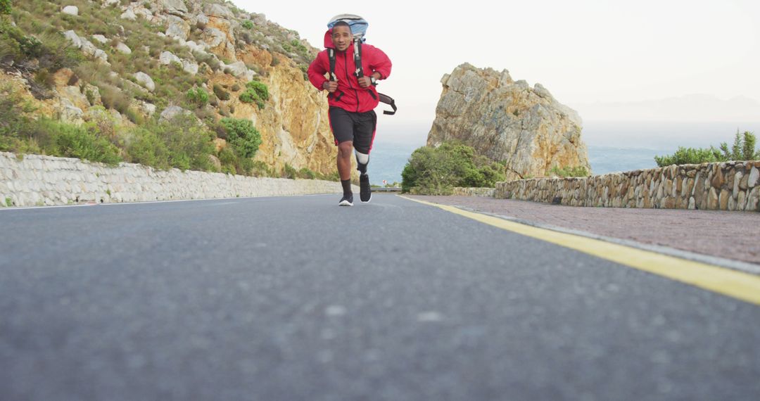 Adaptive Runner with Prosthetic Leg Backpacking on Scenic Road