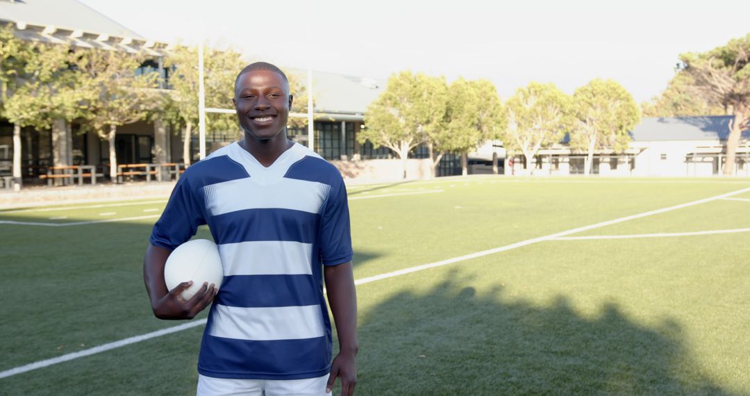 Rugby Player Holding Ball on Field in Sunshine