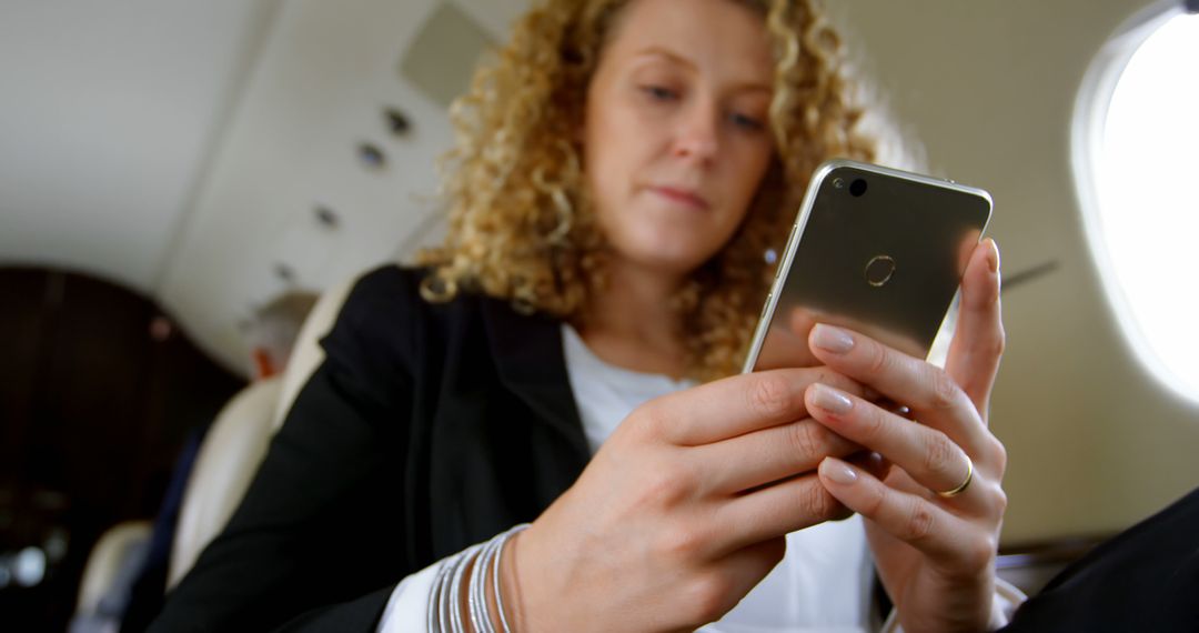 Businesswoman Using Smartphone in Private Jet