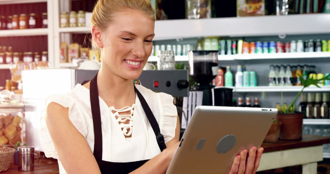 Smiling Female Barista Using Digital Tablet in Coffee Shop - Free Images, Stock Photos and Pictures on Pikwizard.com