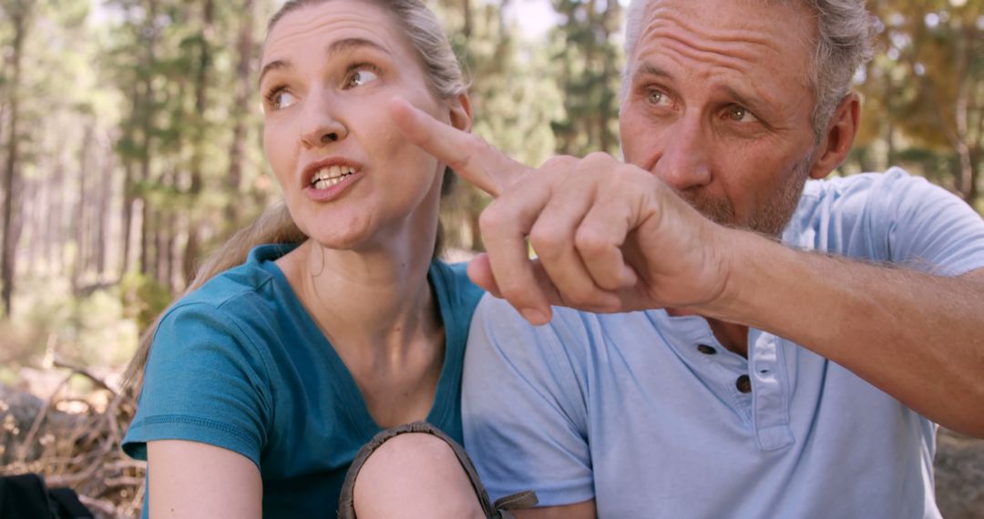 Mature Couple Navigating Hike With Map and Compass in Forest