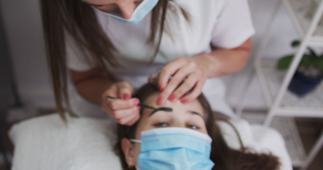 Woman Receiving Eyebrow Treatment During Pandemic in Salon - Free Images, Stock Photos and Pictures on Pikwizard.com