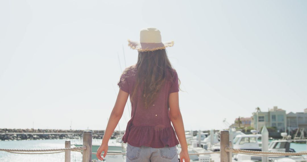 Young Woman in Summer Hat Enjoying Marina View - Free Images, Stock Photos and Pictures on Pikwizard.com