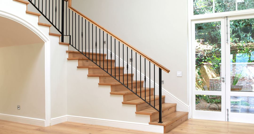 Modern Wooden Staircase with Black Railings in Bright Living Room - Free Images, Stock Photos and Pictures on Pikwizard.com