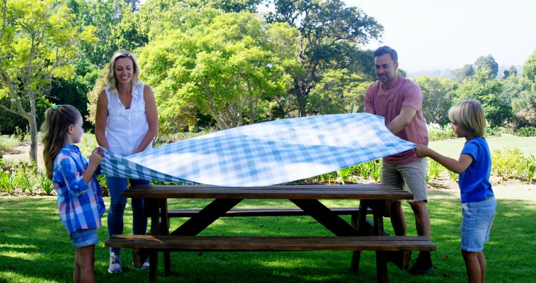 Family Preparing Picnic Table in Park on a Sunny Day - Free Images, Stock Photos and Pictures on Pikwizard.com