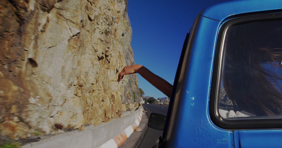 Girl Enjoying Mountain Road Trip in Blue Car on Sunny Day - Free Images, Stock Photos and Pictures on Pikwizard.com