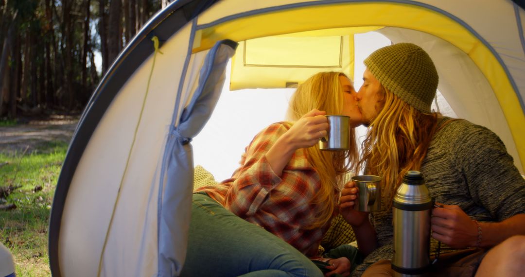 Couple Enjoying Hot Beverages and Kissing in Camping Tent - Free Images, Stock Photos and Pictures on Pikwizard.com