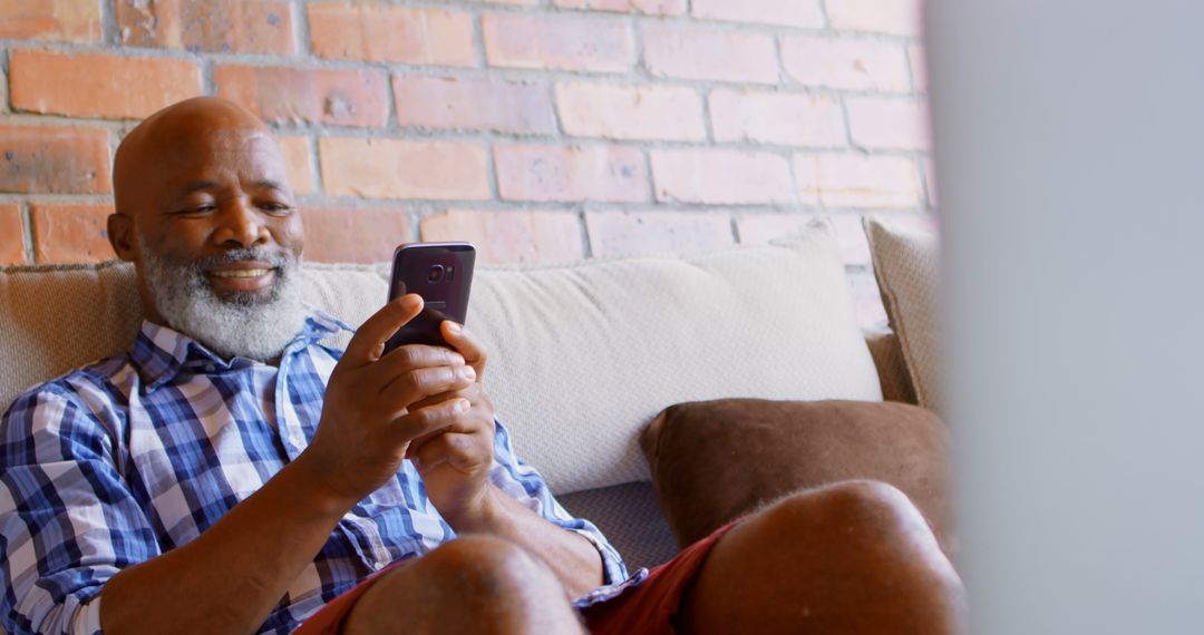 Smiling Elderly Man Using Smartphone At Home - Free Images, Stock Photos and Pictures on Pikwizard.com