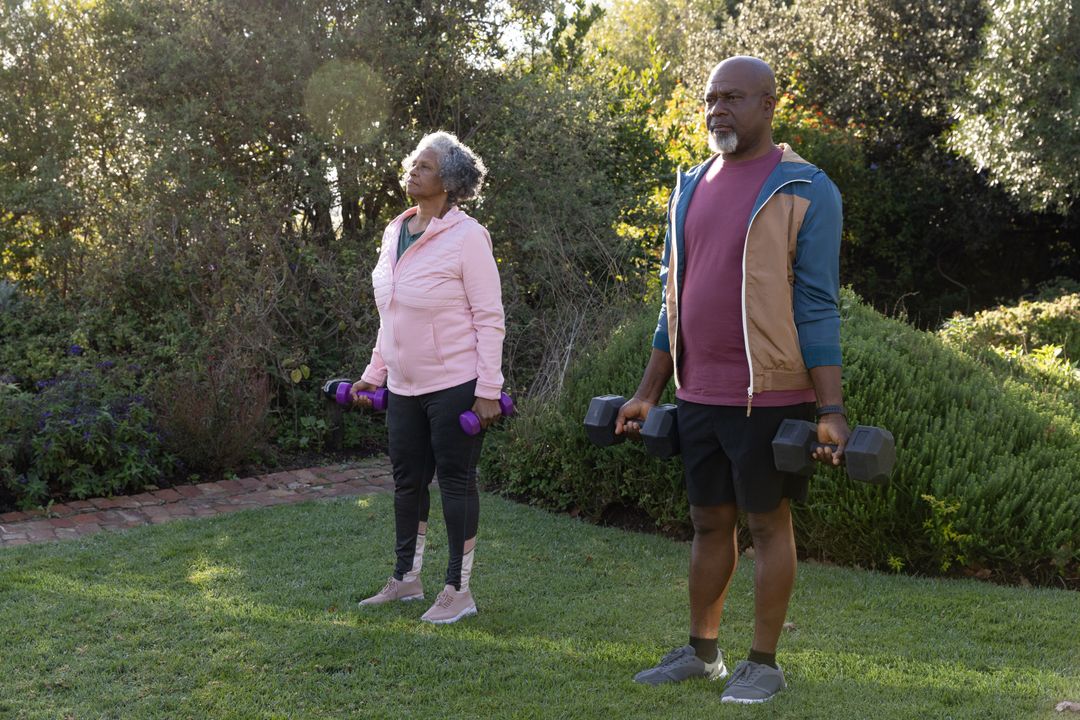 Seniors Exercising with Dumbbells in Backyard Garden